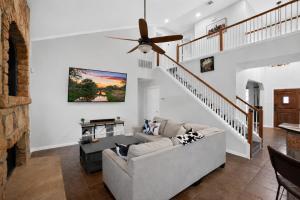 a living room with a couch and a ceiling fan at Spacious 4BR Retreat |Pool Table| Firepit & Hottub in Kyle