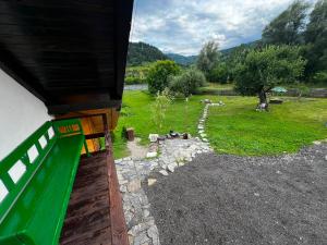 a house with a green door and a field of grass at Casa Adela LaculRosu Bicaz in Neagra