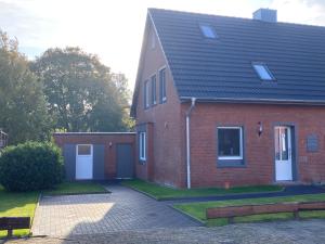 a red brick house with a garage at Ferienhaus Helmshuus in Leer