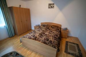 a bedroom with a bed and a wooden floor at Klára House - Covasna in Covasna