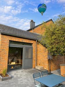 a hot air balloon flying over a building with a patio at Gîte La Petite Villette in Fronville +9 photos
