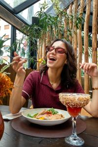 a woman sitting at a table with a plate of food at Flamant Rose Appart Hotel in Tangier +120 photos