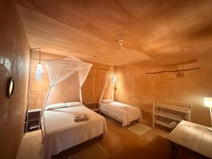 a bedroom with two beds and a ceiling at M a r e a V i v a - Z i p o l i t e in Zipolite