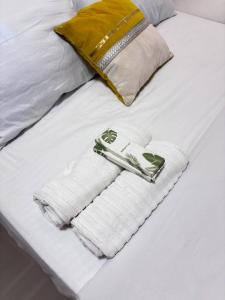 a bed with white towels and a gold purse at Next House Passi City in Iprog