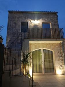 a brick building with a balcony and a door at La casa di Jacopo in Modica