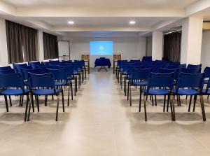 a room with blue chairs and a screen at Caruaru Pallace Hotel in Caruaru