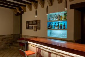 a bar with a wooden counter and bottles on the wall at Hotel Villa de Alquézar in Alquézar