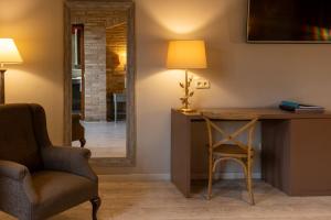 a room with a desk and a chair and a lamp at Hotel Villa de Alquézar in Alquézar