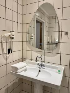 a bathroom with a white sink and a mirror at Orange Parkway Hotel in Diest +41 photos