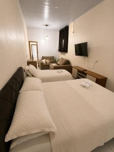 a hotel room with two beds and a couch at Loft Farol in Pântano Grande