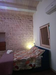 a bedroom with a bed and a brick wall at La casa di Jacopo in Modica