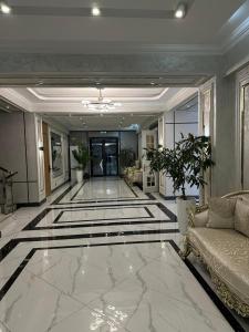 a living room with a large marble floor with a couch at Palace&Spa Rooms in Shymkent