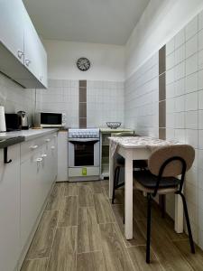 a kitchen with a table and a clock on the wall at Kinizsi House in Szigetszentmiklós
