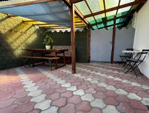 a patio with a table and a bench in a building at Kinizsi House in Szigetszentmiklós