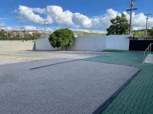 an empty parking lot with a wall and a tree at Caruaru Pallace Hotel in Caruaru