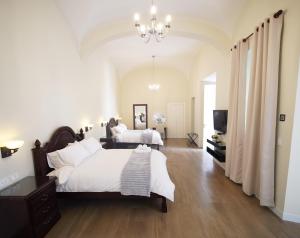 a bedroom with two beds and a chandelier at Patrimonial Hotel Boutique in Cochabamba