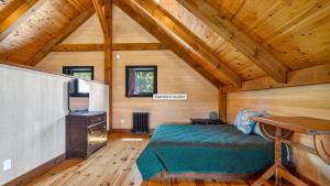 a bedroom with a bed in a room with wooden ceilings at Maison ULTIMA ÉCO in LʼIslet