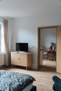 a bedroom with a bed and a television on a cabinet at "LOKAL" Apartment 1 in Bad Muskau