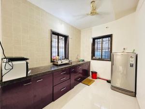 a kitchen with a stainless steel refrigerator in it at Orchid Villa - The Dream Stays ll Big Pvt Pool ll 3Ac room ll Wi-Fi ll Tv in Lonavala