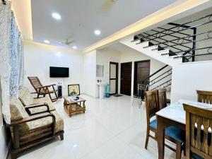 a living room filled with furniture and a staircase at Orchid Villa - The Dream Stays ll Big Pvt Pool ll 3Ac room ll Wi-Fi ll Tv in Lonavala