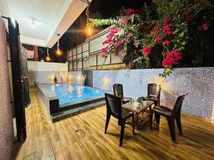 a table and chairs next to a swimming pool at Orchid Villa - The Dream Stays ll Big Pvt Pool ll 3Ac room ll Wi-Fi ll Tv in Lonavala