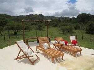 a group of chairs and tables on a patio at TiniHouse AguadePiedra in Villa Giardino