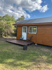 a tiny house with two chairs on a deck at TiniHouse AguadePiedra in Villa Giardino +1 photo