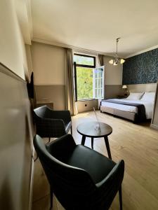 a hotel room with a bed and a table and chairs at Orange Parkway Hotel in Diest