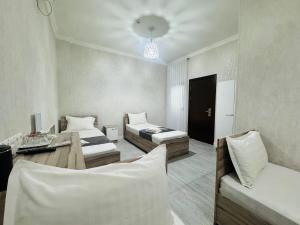 a room with two beds and a desk in it at BOG'DON GRAND Hotel in Tashkent