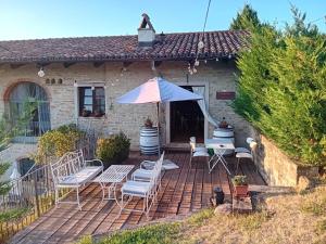 a house with a patio with chairs and an umbrella at Cà Tinola in Mango