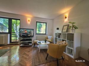 a living room with a tv and a table at Kuća za odmor SLAVIK in Daruvar