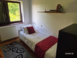 a bed in a room with a window at Kuća za odmor SLAVIK in Daruvar