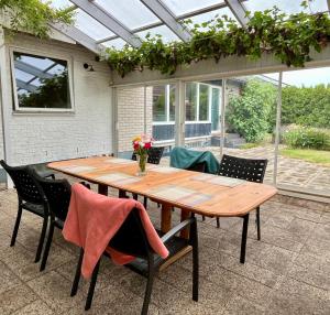 a wooden table and chairs on a patio at Villa María - Charming 40 m2 lower level suite with private entrance in Simrishamn