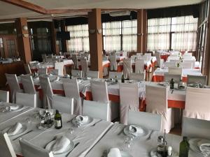 une salle à manger avec des tables et des chaises blanches dans l'établissement Hotel Anfora, à Melilla