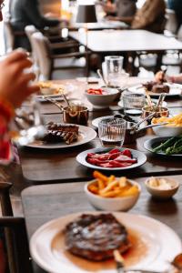 ein Tisch voller Teller mit Essen und Pommes frites in der Unterkunft KG Hotel in Klaksvík