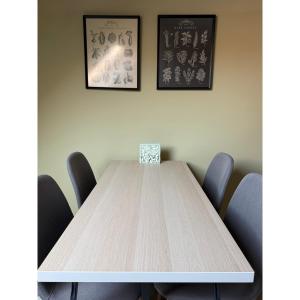 a table with chairs and a vase on top of it at TIÉD Apartman in Kiskunmajsa