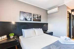 a bedroom with a large white bed and a desk at Exclusivo, Moderno e Completo in Campinas +26 photos