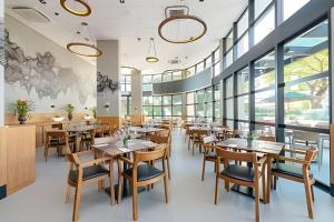 a restaurant with wooden tables and chairs and windows at Exclusivo, Moderno e Completo in Campinas