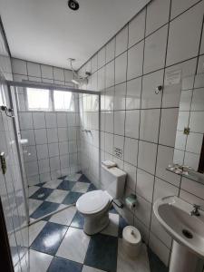 a bathroom with a toilet and a sink at Pousada Tokyo Plaza in Mogi das Cruzes