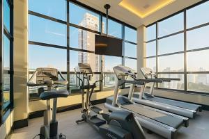 a gym with cardio machines in a building with windows at Exclusivo, Moderno e Completo in Campinas
