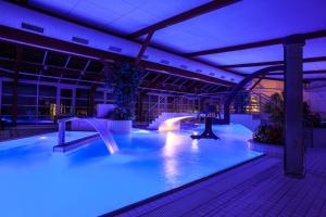 a swimming pool with a slide in a building at Réva in Janske Lazne