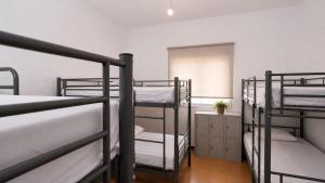 a room with three bunk beds and a window at Guayaba Hostel in Las Lagunas