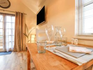 a wooden table with wine glasses on top of it at Tiny Home with Hot Tub in Roydon
