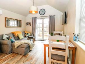 a living room with a couch and a table at Tiny Home with Hot Tub in Roydon
