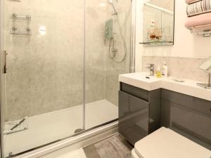 a bathroom with a shower and a toilet and a sink at Tiny Home with Hot Tub in Roydon +12 photos
