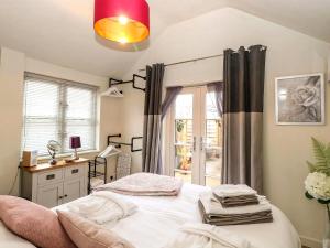 a bedroom with a bed and a window at Tiny Home with Hot Tub in Roydon