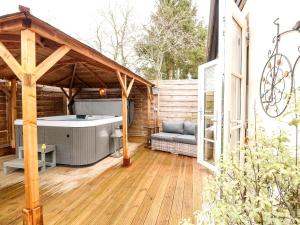 a patio with a hot tub on a wooden deck at Tiny Home with Hot Tub in Roydon