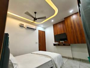 a bedroom with a ceiling fan and a tv at Ora Stay in Pānīpat +19 photos