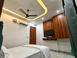 a bedroom with a ceiling fan and a tv at Ora Stay in Pānīpat
