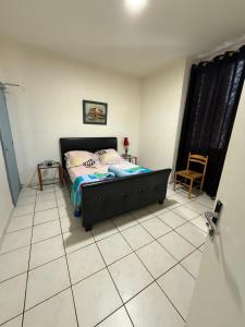 a bedroom with a bed and a tiled floor at Hotel baille castellane in Marseille